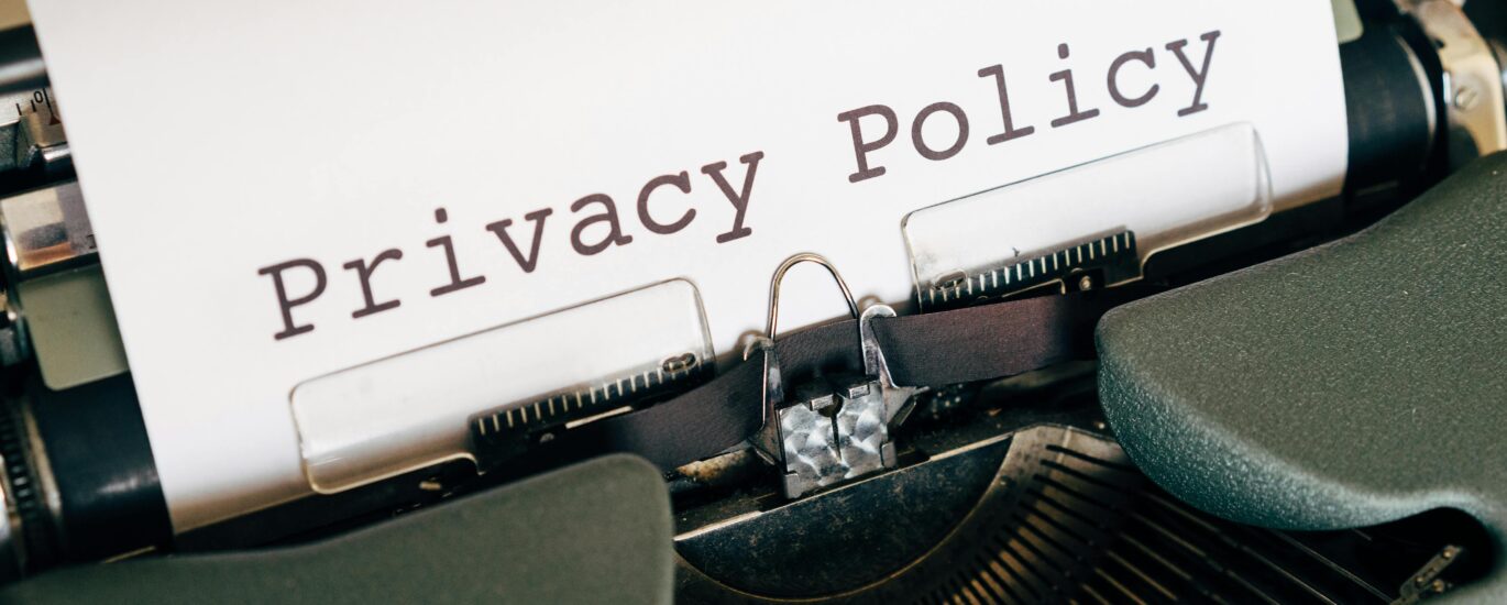 A vintage typewriter writing 'Privacy Policy' on paper, capturing an old-school conceptual theme.