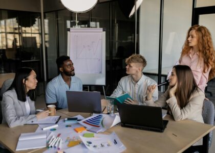 A diverse team discussing business strategy around a conference table in a modern office.